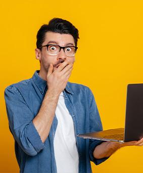 Homme choqué devant son ordinateur